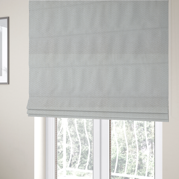 The fabric used to create these Roman blinds is a swatch of textured cream white upholstery fabric.