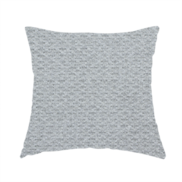 The fabric used to create this handmade cushion is a textured light grey upholstery fabric.