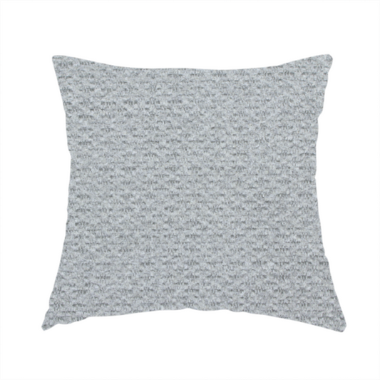 The fabric used to create this handmade cushion is a textured light grey upholstery fabric.