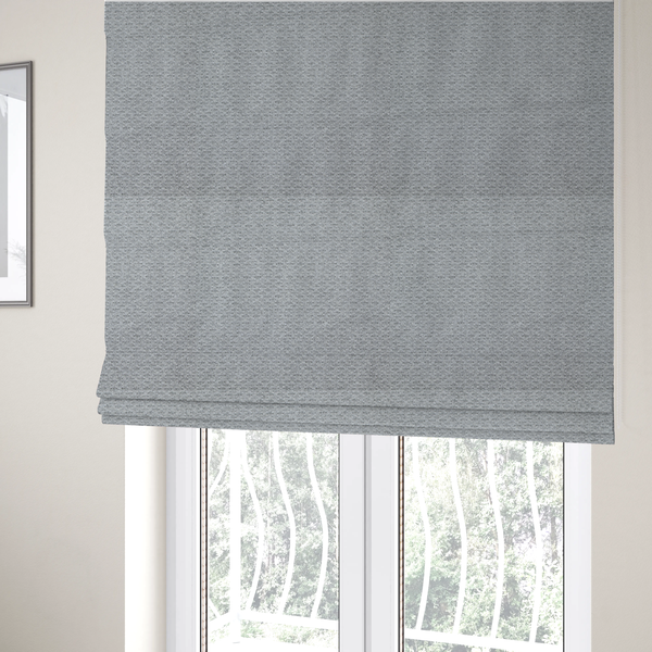 The fabric used to create these Roman blinds is a textured light grey upholstery fabric.