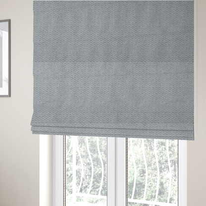 The fabric used to create these Roman blinds is a textured light grey upholstery fabric.