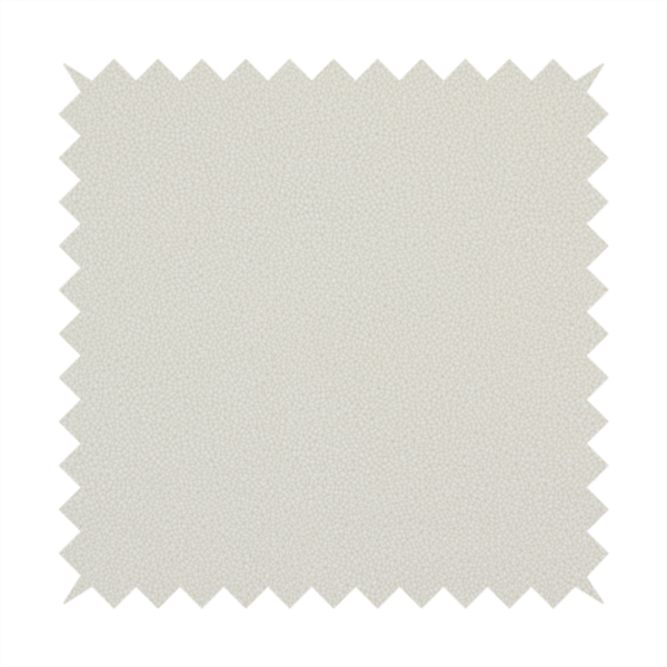 A light beige or off-white suede fabric. The textile features a highly detailed, dense, and uniform embossed pebbled pattern, giving the soft suede material an intricate, tactile texture reminiscent of shagreen.