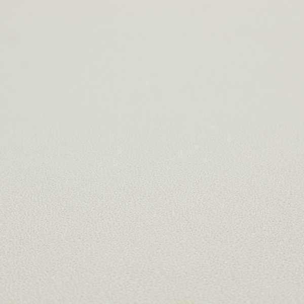 A light beige or off-white suede fabric. The textile features a highly detailed, dense, and uniform embossed pebbled pattern, giving the soft suede material an intricate, tactile texture reminiscent of shagreen.