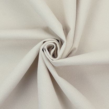 A light beige or off-white suede fabric. The textile features a highly detailed, dense, and uniform embossed pebbled pattern, giving the soft suede material an intricate, tactile texture reminiscent of shagreen.