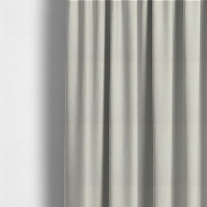 The fabric used to create these made-to-measure curtains is a light beige or off-white suede fabric. The textile features a highly detailed, dense, and uniform embossed pebbled pattern, giving the soft suede material an intricate, tactile texture reminiscent of shagreen.
