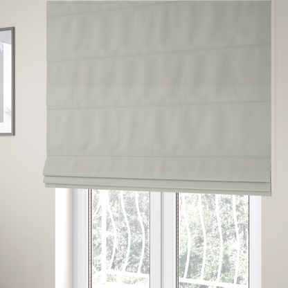 The fabric used to create these Roman blinds is a light beige or off-white suede fabric. The textile features a highly detailed, dense, and uniform embossed pebbled pattern, giving the soft suede material an intricate, tactile texture reminiscent of shagreen.