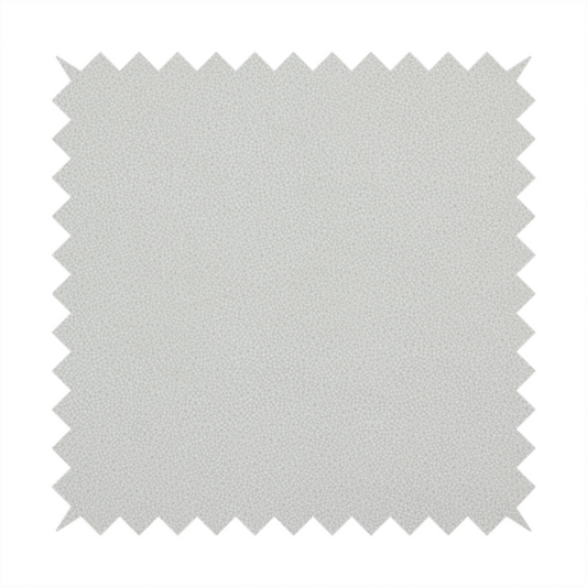 A light grey Merida Suede upholstery fabric. The textile features a highly detailed, dense, and uniform embossed pebbled pattern, giving the soft grey suede material an intricate, tactile shagreen texture.