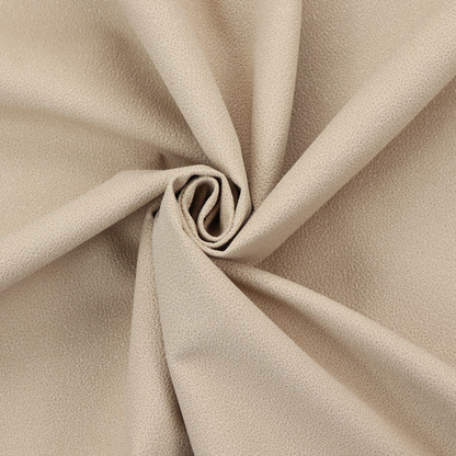 A warm beige or tan Merida Suede upholstery fabric. The textile features a highly detailed, dense, and uniform embossed pebbled pattern, giving the soft suede material an intricate, tactile shagreen texture.