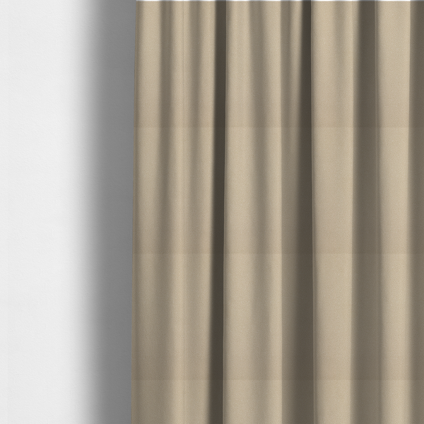 The fabric used to create these made-to-measure curtains is a warm beige or tan Merida Suede upholstery fabric. The textile features a highly detailed, dense, and uniform embossed pebbled pattern, giving the soft suede material an intricate, tactile shagreen texture.