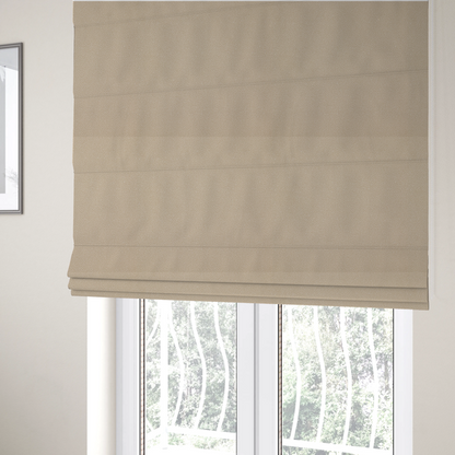 The fabric used to create these Roman blinds is a warm beige or tan Merida Suede upholstery fabric. The textile features a highly detailed, dense, and uniform embossed pebbled pattern, giving the soft suede material an intricate, tactile shagreen texture.