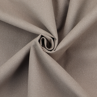 A taupe or dark beige Merida Suede upholstery fabric. The textile features a highly detailed, dense, and uniform embossed pebbled pattern, giving the soft suede material an intricate, tactile shagreen texture.