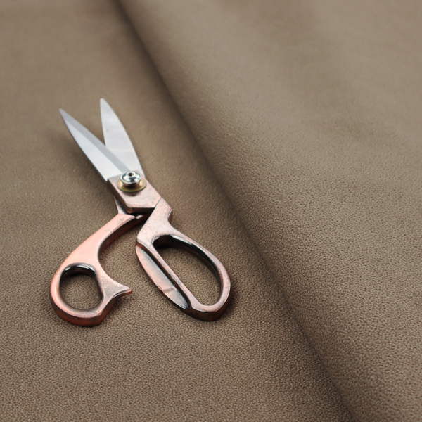 A medium brown Merida Suede upholstery fabric. The textile features a highly detailed, dense, and uniform embossed pebbled pattern, giving the soft suede material an intricate, tactile shagreen texture.