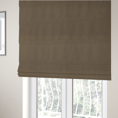 The fabric used to create these Roman blinds is a medium brown Merida Suede upholstery fabric. The textile features a highly detailed, dense, and uniform embossed pebbled pattern, giving the soft suede material an intricate, tactile shagreen texture.