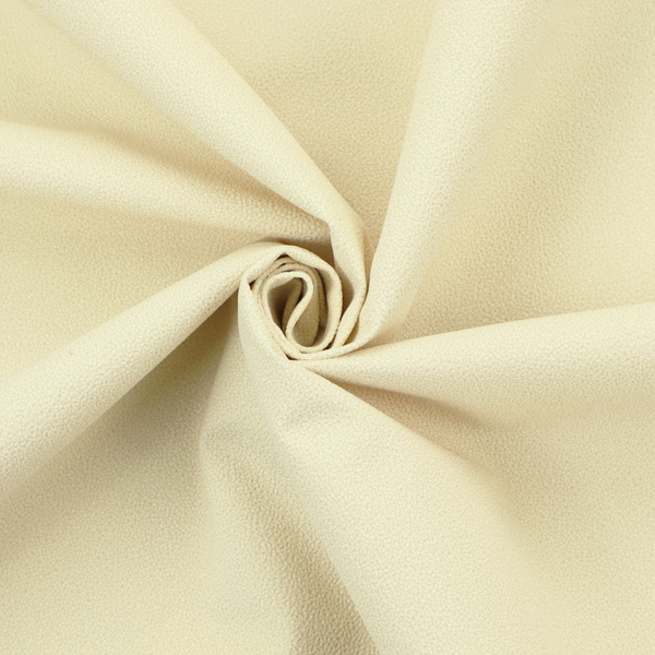 A light cream or soft ivory Merida Suede upholstery fabric. The textile features a highly detailed, dense, and uniform embossed pebbled pattern, giving the soft suede material an intricate, tactile shagreen texture.