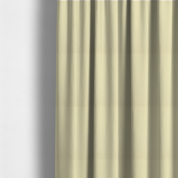 The fabric used to create these made-to-measure curtains is a light cream or soft ivory Merida Suede upholstery fabric. The textile features a highly detailed, dense, and uniform embossed pebbled pattern, giving the soft suede material an intricate, tactile shagreen texture.