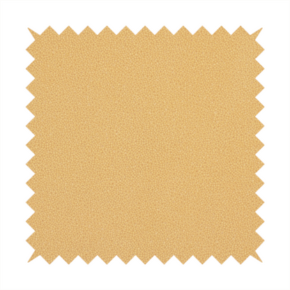 A warm ochre or golden yellow Merida Suede upholstery fabric. The textile features a highly detailed, dense, and uniform embossed pebbled pattern, giving the soft suede material an intricate, tactile shagreen texture.