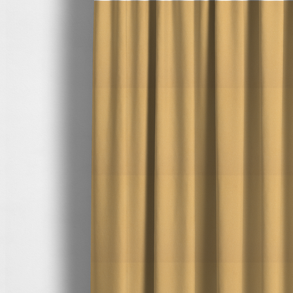 The fabric used to create these made-to-measure curtains is a warm ochre or golden yellow Merida Suede upholstery fabric. The textile features a highly detailed, dense, and uniform embossed pebbled pattern, giving the soft suede material an intricate, tactile shagreen texture.