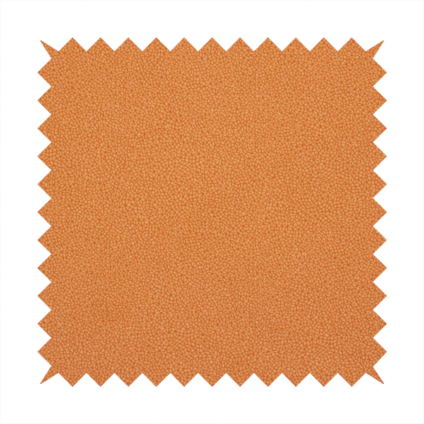 A bright orange or tangerine Merida Suede upholstery fabric. The textile features a highly detailed, dense, and uniform embossed pebbled pattern, giving the soft suede material an intricate, tactile shagreen texture.