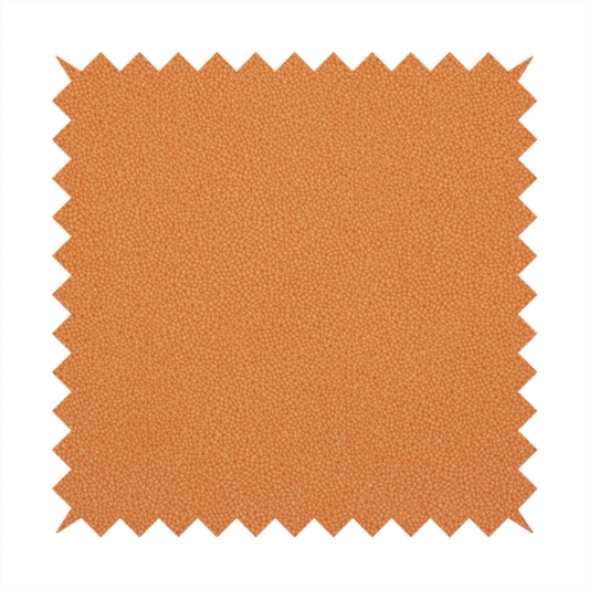 A bright orange or tangerine Merida Suede upholstery fabric. The textile features a highly detailed, dense, and uniform embossed pebbled pattern, giving the soft suede material an intricate, tactile shagreen texture.
