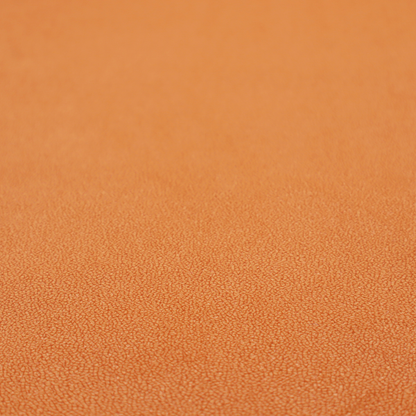 A bright orange or tangerine Merida Suede upholstery fabric. The textile features a highly detailed, dense, and uniform embossed pebbled pattern, giving the soft suede material an intricate, tactile shagreen texture.
