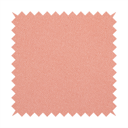 A soft salmon pink or coral Merida Suede upholstery fabric. The textile features a highly detailed, dense, and uniform embossed pebbled pattern, giving the soft suede material an intricate, tactile shagreen texture.