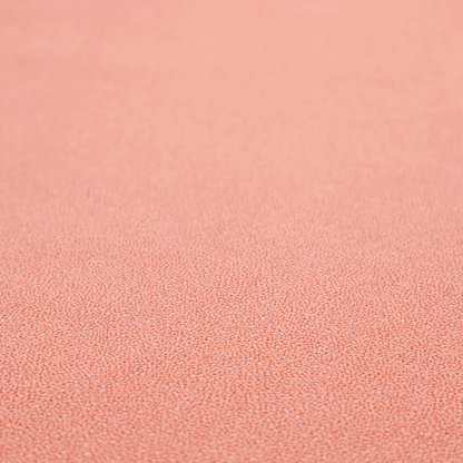 A soft salmon pink or coral Merida Suede upholstery fabric. The textile features a highly detailed, dense, and uniform embossed pebbled pattern, giving the soft suede material an intricate, tactile shagreen texture.