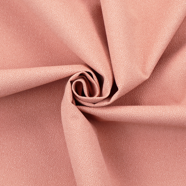 A soft salmon pink or coral Merida Suede upholstery fabric. The textile features a highly detailed, dense, and uniform embossed pebbled pattern, giving the soft suede material an intricate, tactile shagreen texture.
