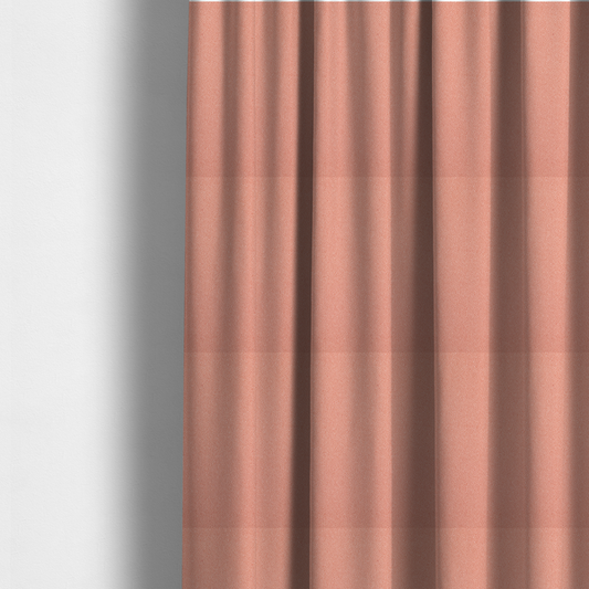 The fabric used to create these made-to-measure curtains is a soft salmon pink or coral Merida Suede upholstery fabric. The textile features a highly detailed, dense, and uniform embossed pebbled pattern, giving the soft suede material an intricate, tactile shagreen texture.