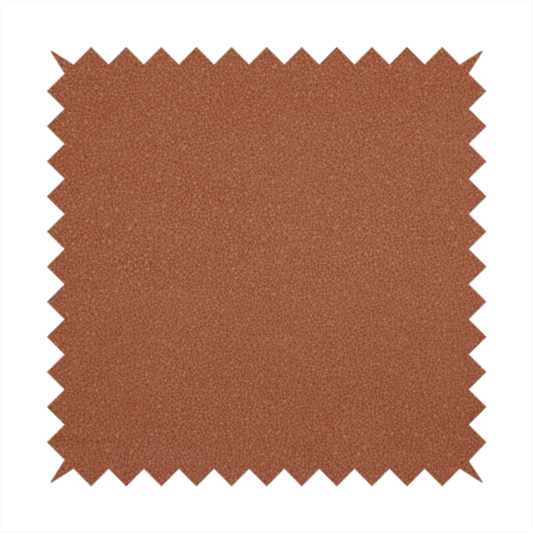 A warm terracotta or rust orange Merida Suede upholstery fabric. The textile features a highly detailed, dense, and uniform embossed pebbled pattern, giving the soft suede material an intricate, tactile shagreen texture.