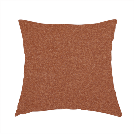 The fabric used to create this handmade cushion is a warm terracotta or rust orange Merida Suede upholstery fabric. The textile features a highly detailed, dense, and uniform embossed pebbled pattern, giving the soft suede material an intricate, tactile shagreen texture.