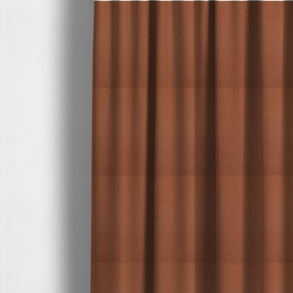 The fabric used to create these made-to-measure curtains is a warm terracotta or rust orange Merida Suede upholstery fabric. The textile features a highly detailed, dense, and uniform embossed pebbled pattern, giving the soft suede material an intricate, tactile shagreen texture.