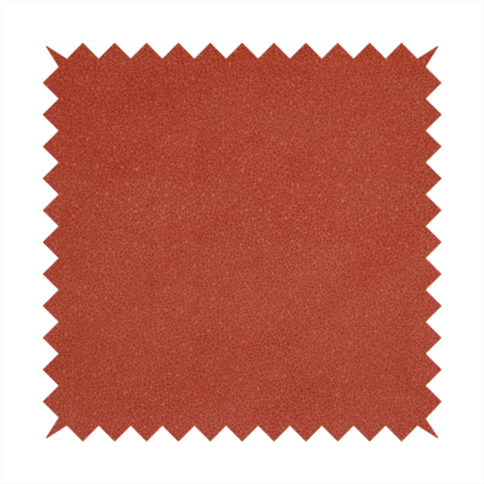 A vibrant brick red or rust Merida Suede upholstery fabric. The textile features a highly detailed, dense, and uniform embossed pebbled pattern, giving the soft suede material an intricate, tactile shagreen texture.