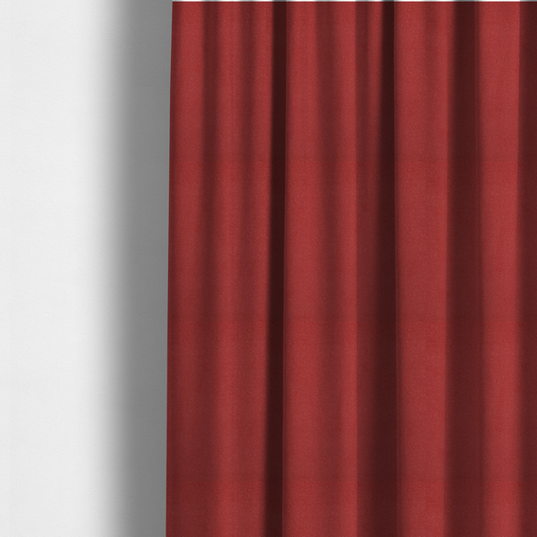 The fabric used to create these made-to-measure curtains is a rich crimson or deep red Merida Suede upholstery fabric. The textile features a highly detailed, dense, and uniform embossed pebbled pattern, giving the soft suede material an intricate, tactile shagreen texture.