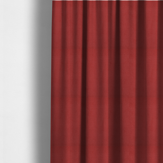 The fabric used to create these made-to-measure curtains is a rich crimson or deep red Merida Suede upholstery fabric. The textile features a highly detailed, dense, and uniform embossed pebbled pattern, giving the soft suede material an intricate, tactile shagreen texture.