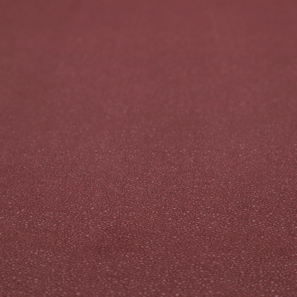 A suede fabric in a deep, muted maroon or burgundy colour.