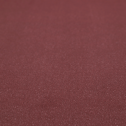 A suede fabric in a deep, muted maroon or burgundy colour.