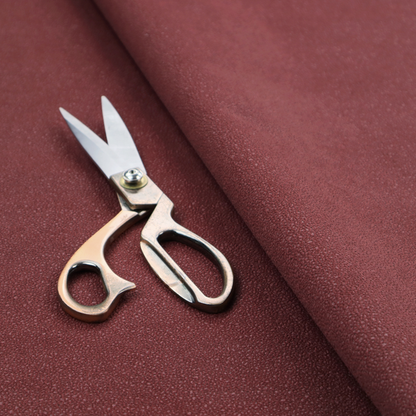 A suede fabric in a deep, muted maroon or burgundy colour.