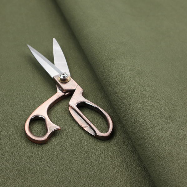 A Merida Suede upholstery fabric in a muted olive green or sage colour.