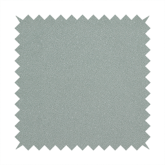 A Merida Suede upholstery fabric in a light sage or pale eucalyptus green colour.