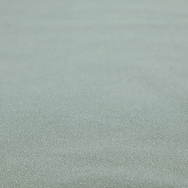 A Merida Suede upholstery fabric in a light sage or pale eucalyptus green colour.