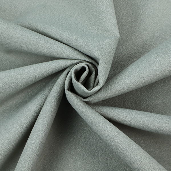 A Merida Suede upholstery fabric in a light sage or pale eucalyptus green colour.
