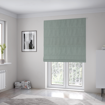The fabric used to create these Roman blinds is a Merida Suede upholstery fabric in a light sage or pale eucalyptus green colour.