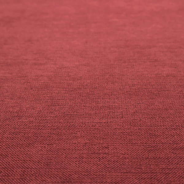 A finely textured weave in a dusty rose or muted red colour. The material features a subtle heathered look with tiny variations of darker and lighter threads throughout.