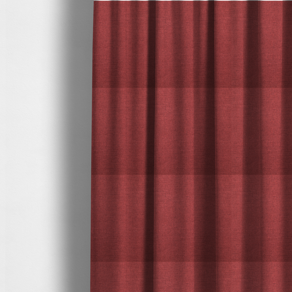 The fabric used to create these made-to-measure curtains is a finely textured weave in a dusty rose or muted red colour. The material features a subtle heathered look with tiny variations of darker and lighter threads throughout.