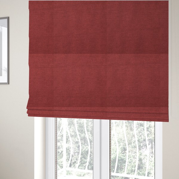 The fabric used to create these Roman blinds is a finely textured weave in a dusty rose or muted red colour. The material features a subtle heathered look with tiny variations of darker and lighter threads throughout.