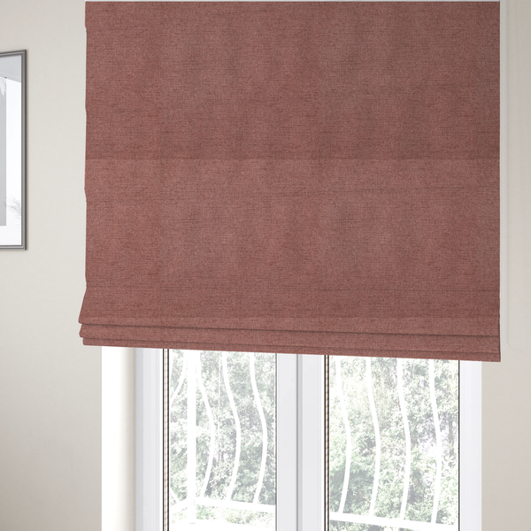 The fabric used to create these Roman blinds is a finely textured weave in a soft, dusty rose or blush pink shade. The material has a subtle heathered appearance with fine variations of lighter pink and darker undertones throughout.
