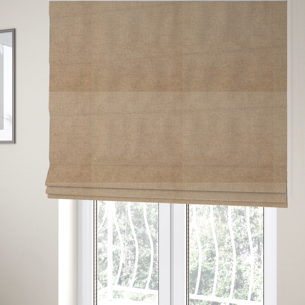 The fabric used to create these Roman blinds is a finely textured weave in a sandy tan or camel shade. The material features a subtle heathered look with mixed light brown, cream, and neutral undertones throughout.