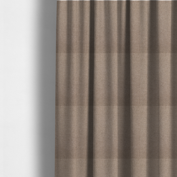 The fabric used to create these made-to-measure curtains is a finely textured weave in a warm taupe or light brownish-grey shade. The material features a subtle heathered look with finely blended threads of tan, cream, and soft brown undertones throughout.