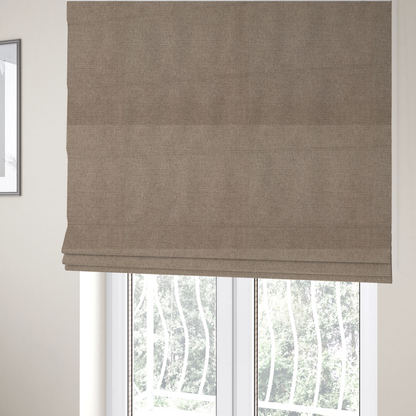 The fabric used to create these Roman blinds is a finely textured weave in a warm taupe or light brownish-grey shade. The material features a subtle heathered look with finely blended threads of tan, cream, and soft brown undertones throughout.