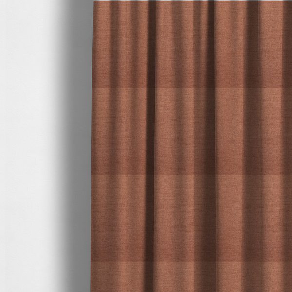 The fabric used to create these made-to-measure curtains is a finely textured weave in a soft terracotta, rust, or muted copper shade. The material features a subtle heathered look with finely blended threads of warm orange-brown and darker neutral undertones throughout.